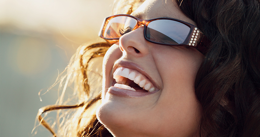 cacausian woman head tilted back laughing sunshine beautiful smile