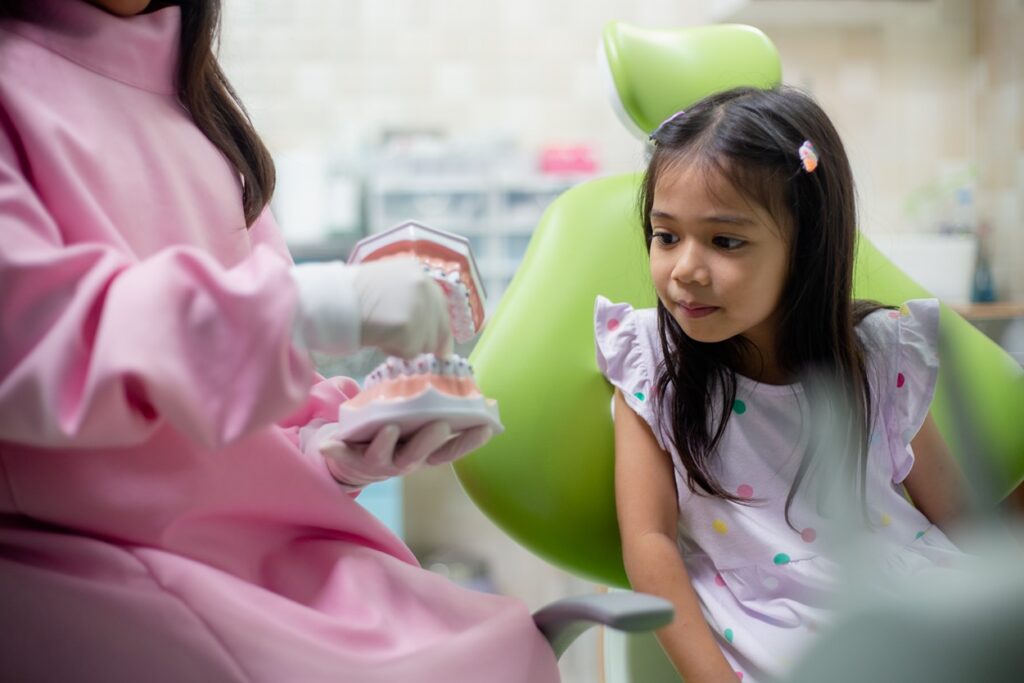 Young child learning about dental care during a pediatric dental visit.