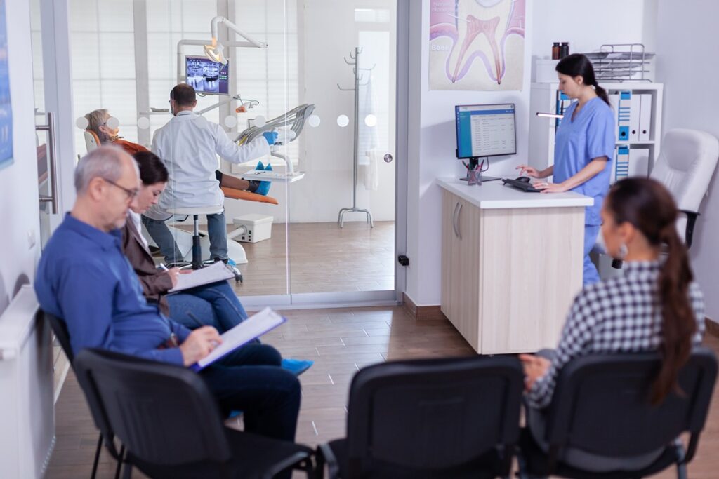 Patients waiting in a dental clinic reception area.