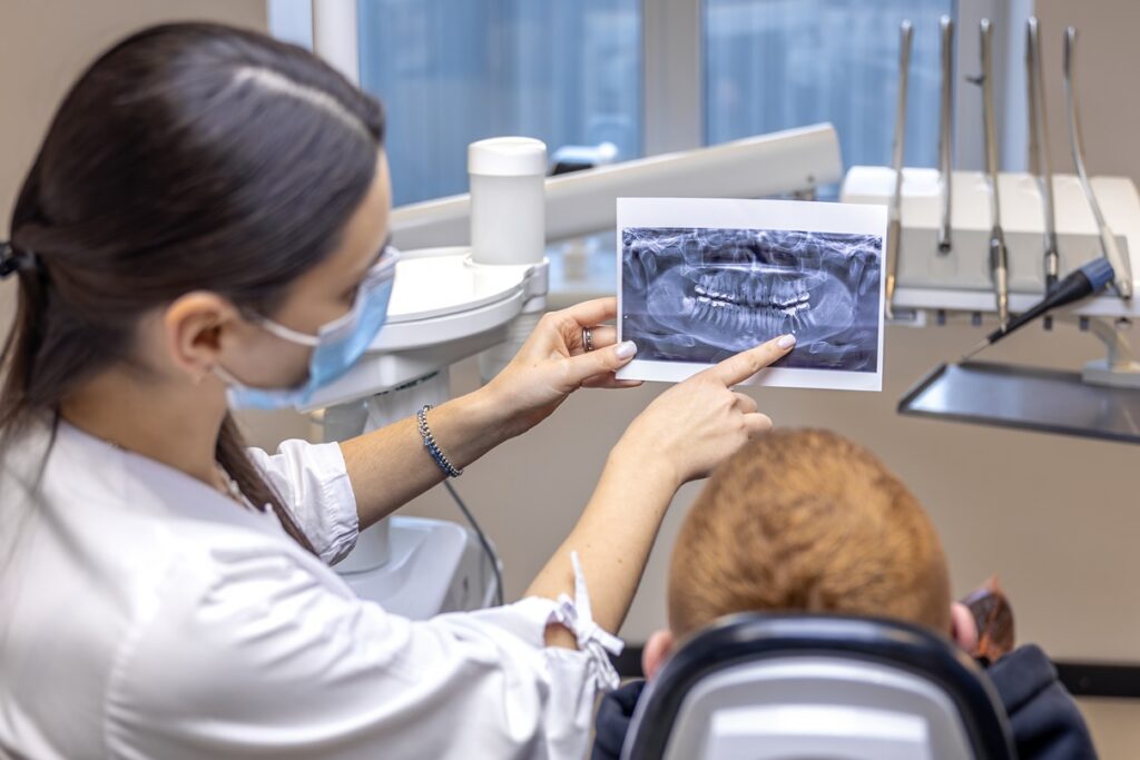 Dentist explaining dental X-ray results to a patient.