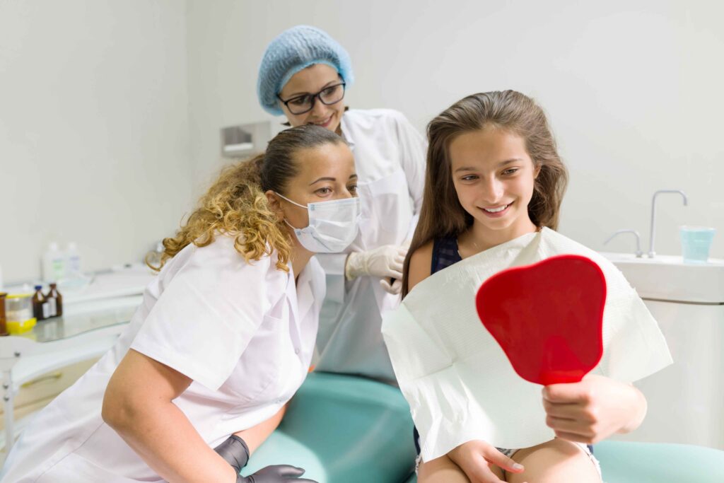 Child checking smile with dentist.